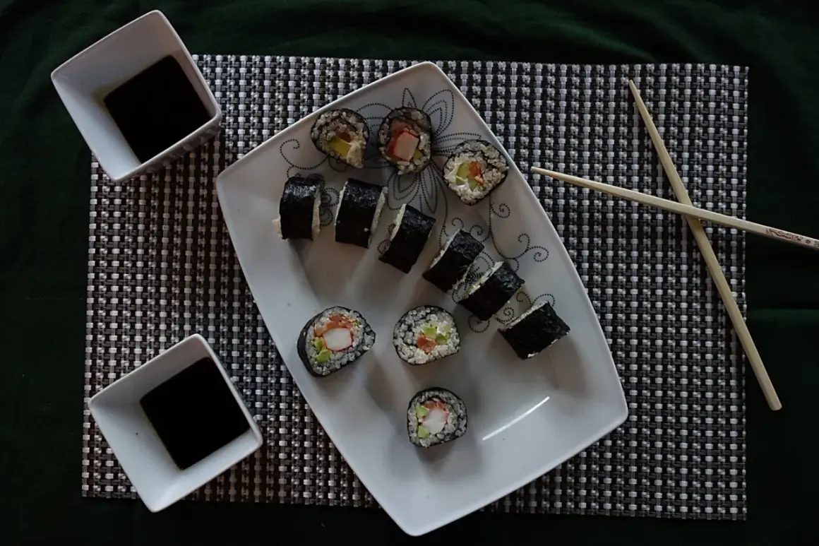 Pyszne domowe sushi z łososiem i awokado, podane z sosem sojowym.